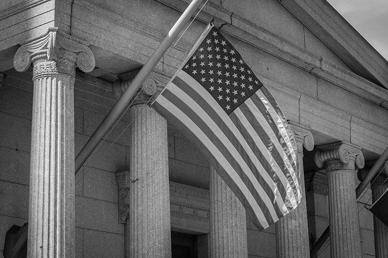 united states flag in front of a courthouse