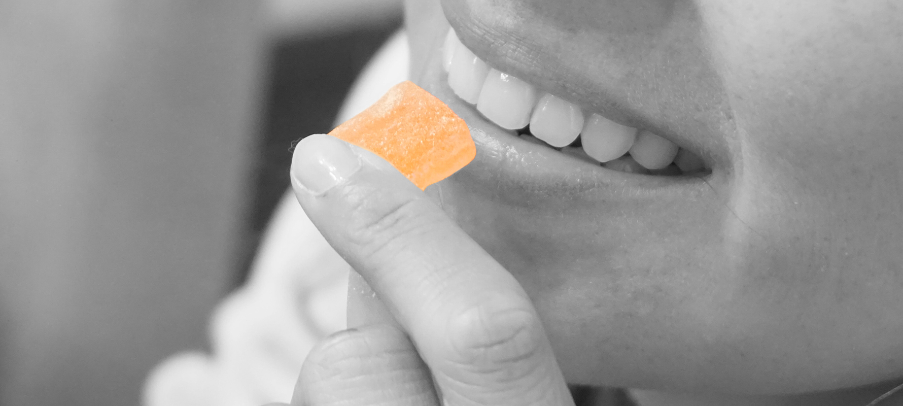 a lady eating a orange gummy